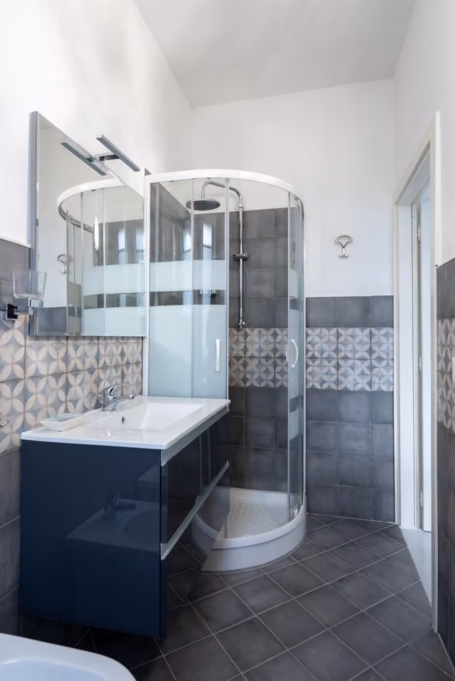 Bagno con lavandino e doccia di una camera del B & B L'ABBRACCIO